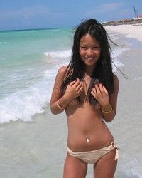 Азиатка позирует перед камерой на пляже 1 фото