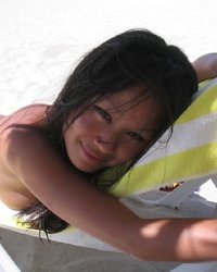 Азиатка позирует перед камерой на пляже 5 фотография