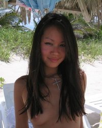 Азиатка позирует перед камерой на пляже 7 фото