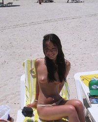 Азиатка позирует перед камерой на пляже 4 фото