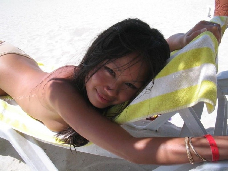 Азиатка позирует перед камерой на пляже 5 фото