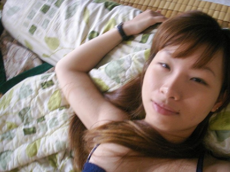 Азиатка делает селфи для парня, развалившись в постели 1 фото