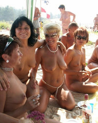 Компания нудистов веселится на пляже 4 фото