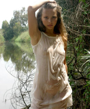 Милая девушка у реки в мокрой сорочке
