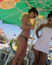 Две подруги разделись под зонтом на пляже 7 фотография