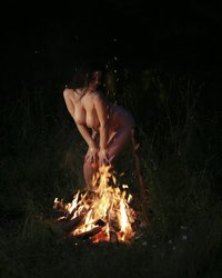 Пышная женщина позирует голая возле костра 3 фотография