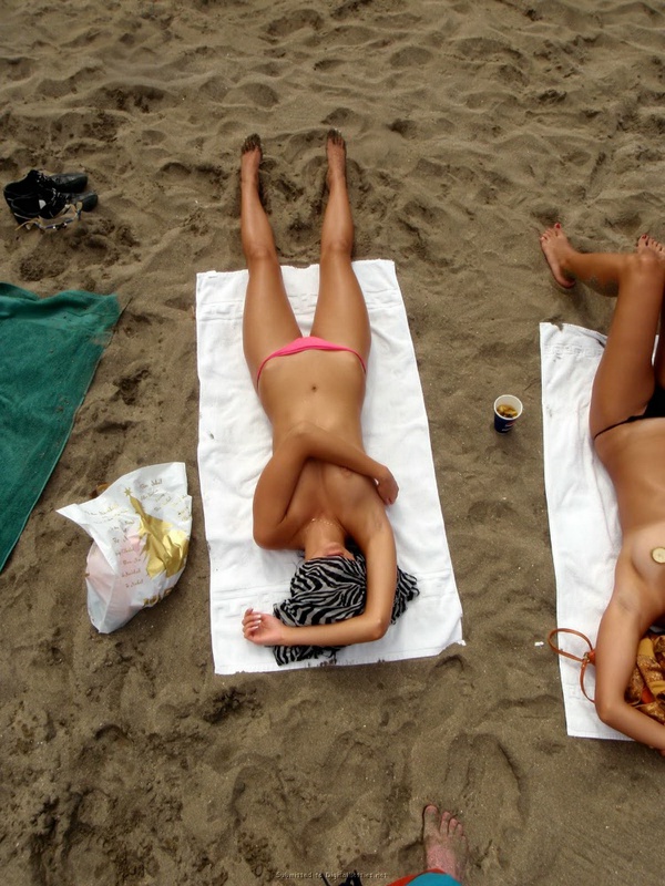 Развратная девушка загорает на пляже топлесс 19 фото