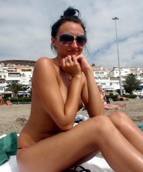 Развратная девушка загорает на пляже топлесс