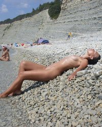 Обнаженная женщина на камянистом берегу 3 фотография