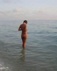 Обнаженная женщина на камянистом берегу 7 фотография