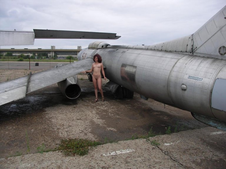 Брюнеточка позирует у старого самолета 6 фото