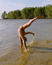 Эротичная гимнасточка голышом тренируется на речном берегу 13 фотография