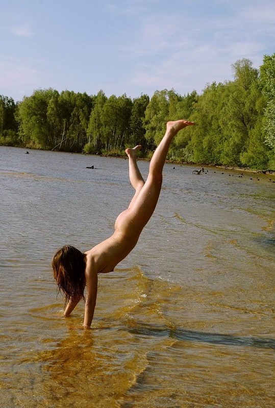 Эротичная гимнасточка голышом тренируется на речном берегу 14 фото