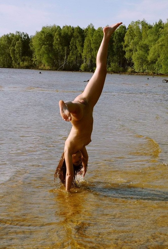 Эротичная гимнасточка голышом тренируется на речном берегу 12 фото