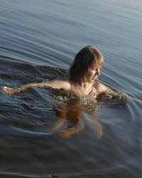 Светловолосая нимфа плавает в озере без купальника 5 фотография