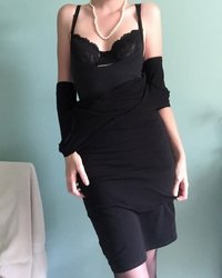Длинноногая красотка в черном платье светит обнаженным телом 4 фотография