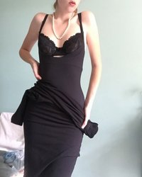 Длинноногая красотка в черном платье светит обнаженным телом 5 фотография
