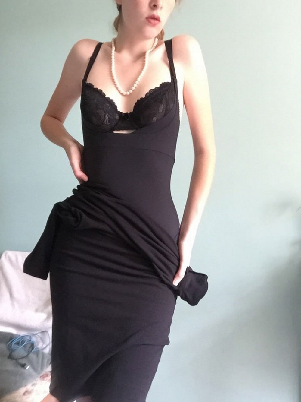 Длинноногая красотка в черном платье светит обнаженным телом 5 фото