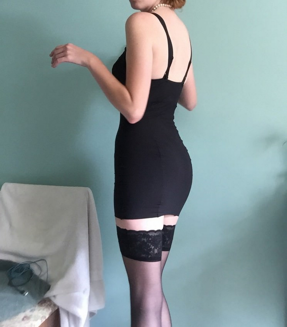 Длинноногая красотка в черном платье светит обнаженным телом 6 фото