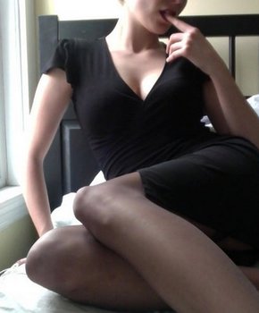Сексуальная девица в черном белье и чулках позирует перед камерой