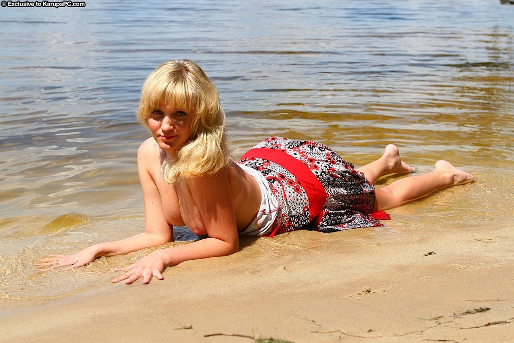 Блондинка в платье зашла в воду, показала стриптиз и присела на бревно 5 фото