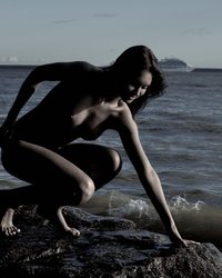 Молодуха на скалистом берегу моря светит обнаженным телом 4 фото