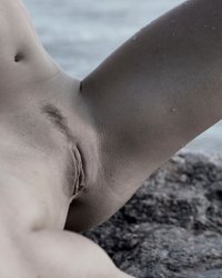 Молодуха на скалистом берегу моря светит обнаженным телом 6 фото