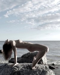 Молодуха на скалистом берегу моря светит обнаженным телом 13 фотография