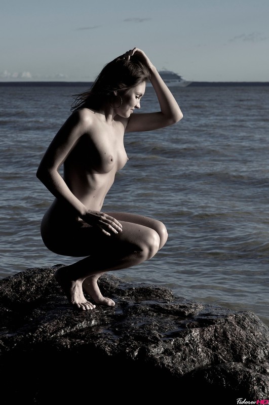 Молодуха на скалистом берегу моря светит обнаженным телом 3 фото
