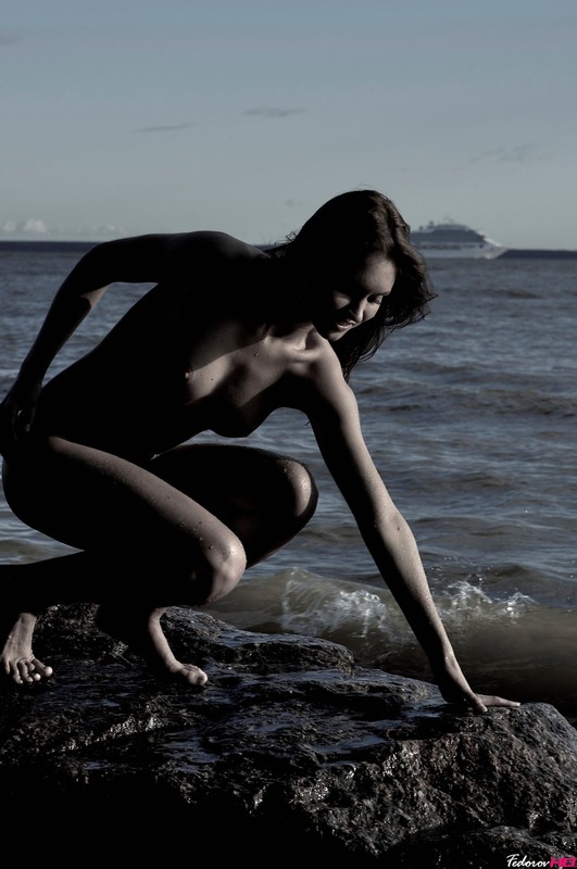 Молодуха на скалистом берегу моря светит обнаженным телом 4 фото